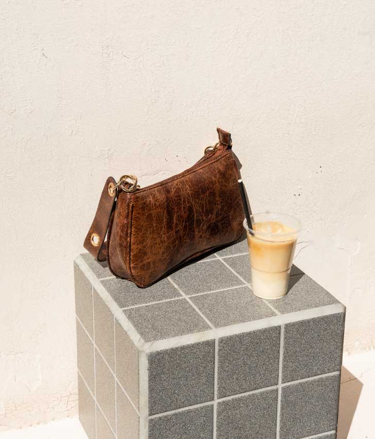 Bolso de hombro marrón con argollas en el asa